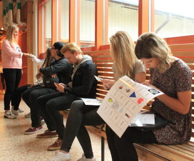 I förgrunden sitter Isabella och Emma och klipper ut ett svenska-träningsmemory några av eleverna skapat. Bilder ska kombineras med ordet för att få ett par. Ord-, läs- och stavningsträning på samma gång. I bakgrunden syns Jonna, Amelie, Enzo och Jesper.<br />