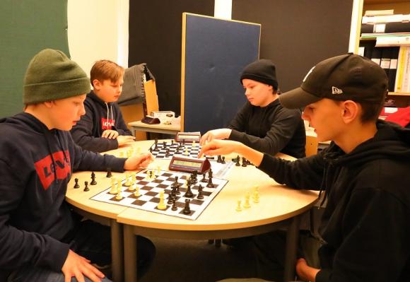 Simon, Theo, Alex och Emil tränar inför Skollags-SM i schack. Lagkompisarna Ellton och Filip är sjuka dagen UBRO kommer på besök.