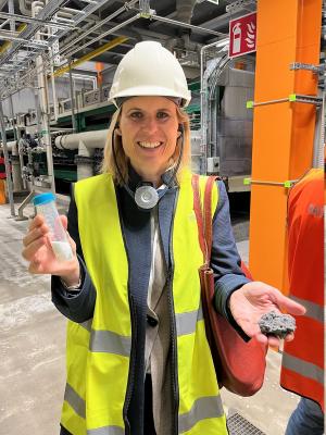 Katarina Barter, Näringslivschef i Upplands-Bro kommun, visar upp det utvunna saltet och den tvättade flygaskan som när den gått igenom utvinningsprocessen blir som en lera eller pasta.