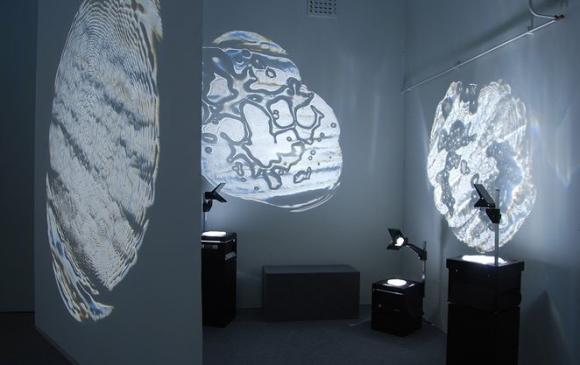Kristina Levén skapar glaskonstverk som projiceras på väggarna med hjälp av overheadapparater. Skuggor av glas heter utställningen.